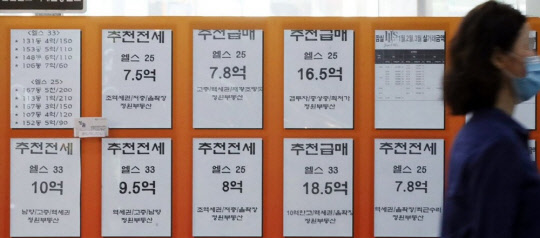 한 시민이 아파트 급매물 시세가 게재된 부동산공인중개업소 앞을 지나가고 있다.<연합뉴스>